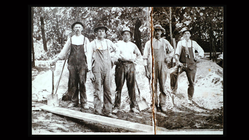 Gammelt bilde av fem menn i arbeidstøy, kledd for skogsarbeid eller tømmerfløting. Bilde ca. datert til starten av 1900-tallet.