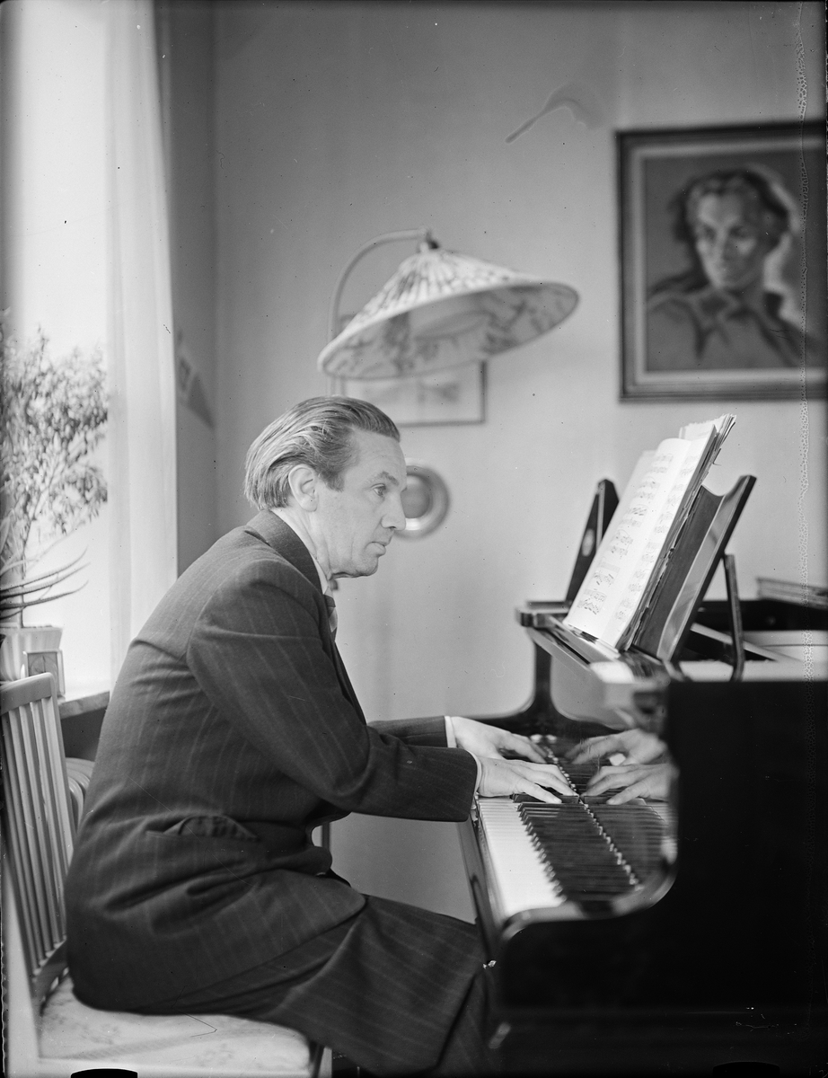 Konstnären Ågren vid flygeln i hemmet, Uppsala 1946
