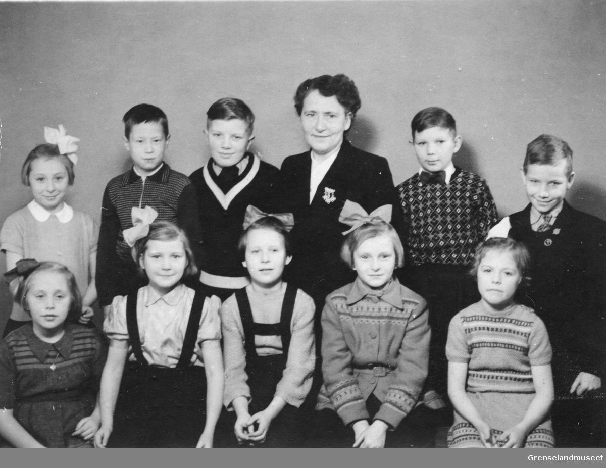 Jordmor Nelly Lund fotografert sammen med ti tunnelbarn, 10 år etter krigens slutt. 