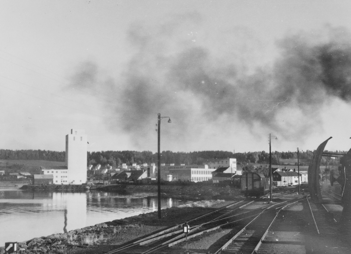 Utsikt fra fyrbøterplassen på damplokomotiv type 63a idet toget kjører inn på Steinkjer stasjon.