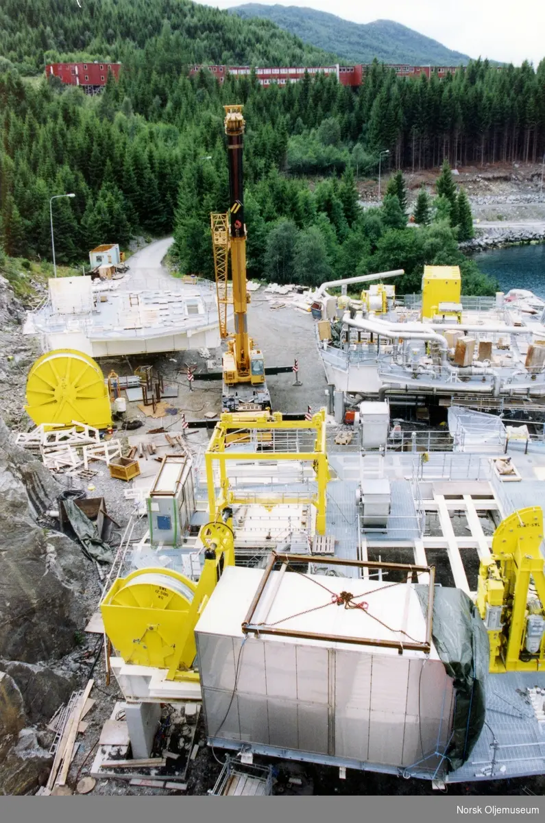 Draugen er under bygging i Yrkjefjorden i Vats, og dekksdeler til plattformen ligger klar på land, før de skal heises og monters ombord i betongskaftet.