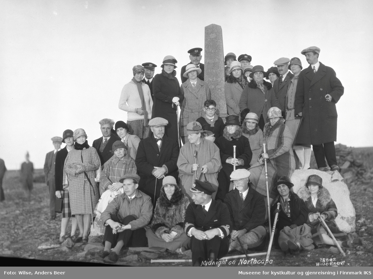 Gruppebilde. Passagerer fra D/S "Bergensfjord" ved Oscarstøtten på Nordkapp-platået. Juli 1926. (Originalnegativet eies av Norsk Folkemuseum, W 28842)