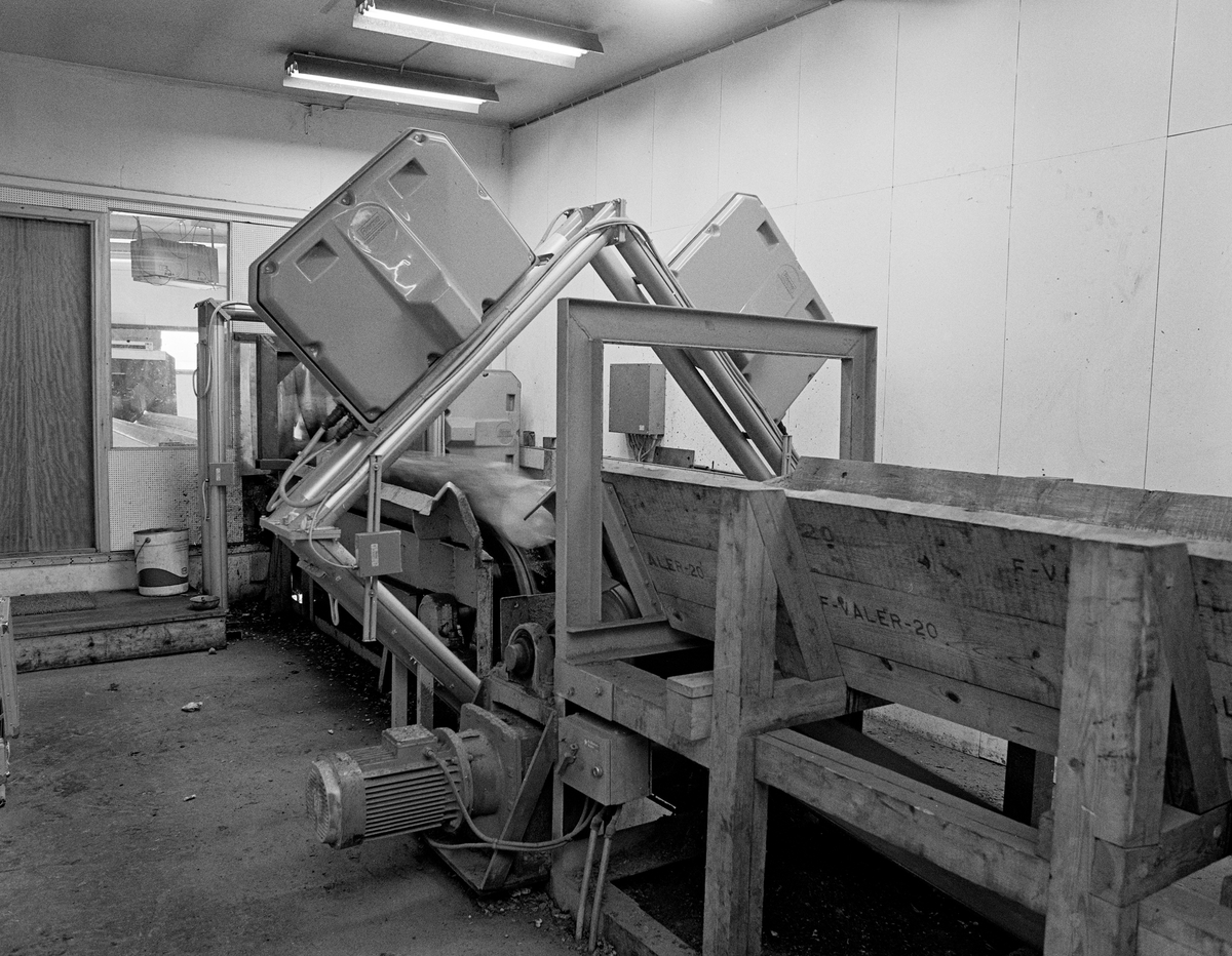 Automatisert tømmermåling ved Våler skurlag på Braskereidfoss i Solør, fotografert våren 1983, da denne teknologien var ny.  Tømmerstokkene gikk raskt gjennom målerhuset på et bånd.  Først passerte de ei ramme med en metallsøker, som skulle avsløre eventuelle metallsplinter, som kunne skape problmer i sagbruket.  Metall i tømmeret var et problem som var særlig vanlig i tømmerpartier som var avvirket i nærheten av det militære øvingsfeltet på Haslemoen i Våler.  Etter å ha passert metallsøkeren ble stokkene diametermålt ved passering av tre rammer (kryssmåling). Lengdemålinga ble gjort ved hjelp av fotoceller.  Under vegs ble stokkene besiktiget av tømmermålerne Rolf Sætre og Ola Strætkvern, som skulle besiktige tømmerstokkene og omklassifisere dersom de påviste feil som det automatiske måleranlegget ikke hadde registrert.    Målerne var særlig observante med hensyn til krok og gankvist.  Operatørene satt ved en terminal der de kunne lese av lengde- og diametermål, med og uten bark.  Maskinen hadde også en barktjukkelsestabell, samt kodesustemer for treslag, sortiment, kvalitet og barktjukkelse.  Våler skurlag mottok på dette tømmer med diamter ned til 10 centimeter (uten bark) for skurlastproduksjon.  Gjennom måleranlegget kunne det gå opptil 5 000 stokker i løpet av et arbeidsskift.  Etter å ha passert målerhuset ble stokkene ført videre på transportbåndet og vippet over i «lommer» for bestemte diameterklasser, vanligvis med intervaller på 2 centimeter.  Ved å mate sagbruket med store serier av tømmerstokker med samme dimensjon unngikk man hyppige omstillinger av sagbruksmaskineriet.