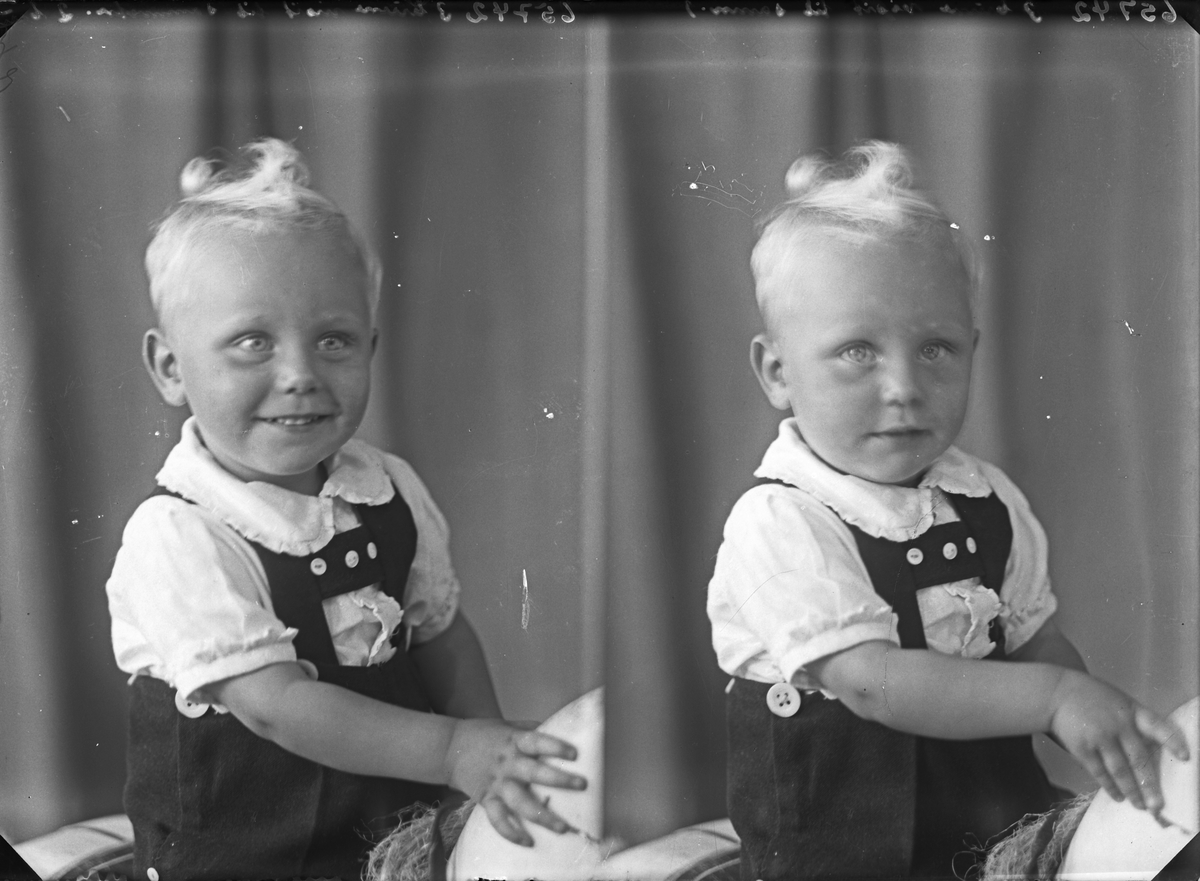 Portrett. Ung lyshåret gutt med vilter frisyre ikledd snekkebokse poserer med en gyngehest.  Bestilt av Olav Vikse. Nygård.