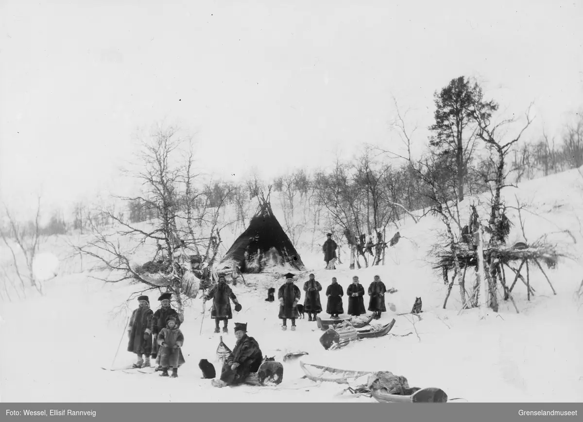 Samisk leir og læstadiansk samling på fjellet ovenfor Sandnesdalen, Sør-Varanger vinteren 1897. Vappus Jon Must står midt i bildet med lua i hånda.