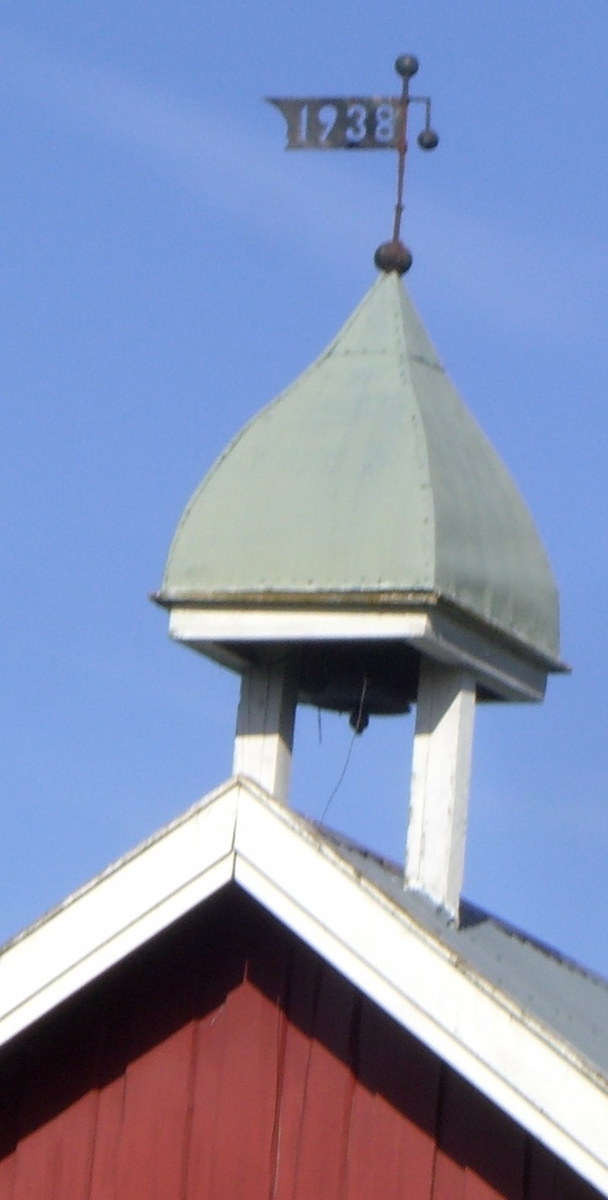 Klokketårnet på Skramstad vestre har buet telttak og er utført i en enkel stil. Klokketårnet står på stabburet, og er i middels til god stand.