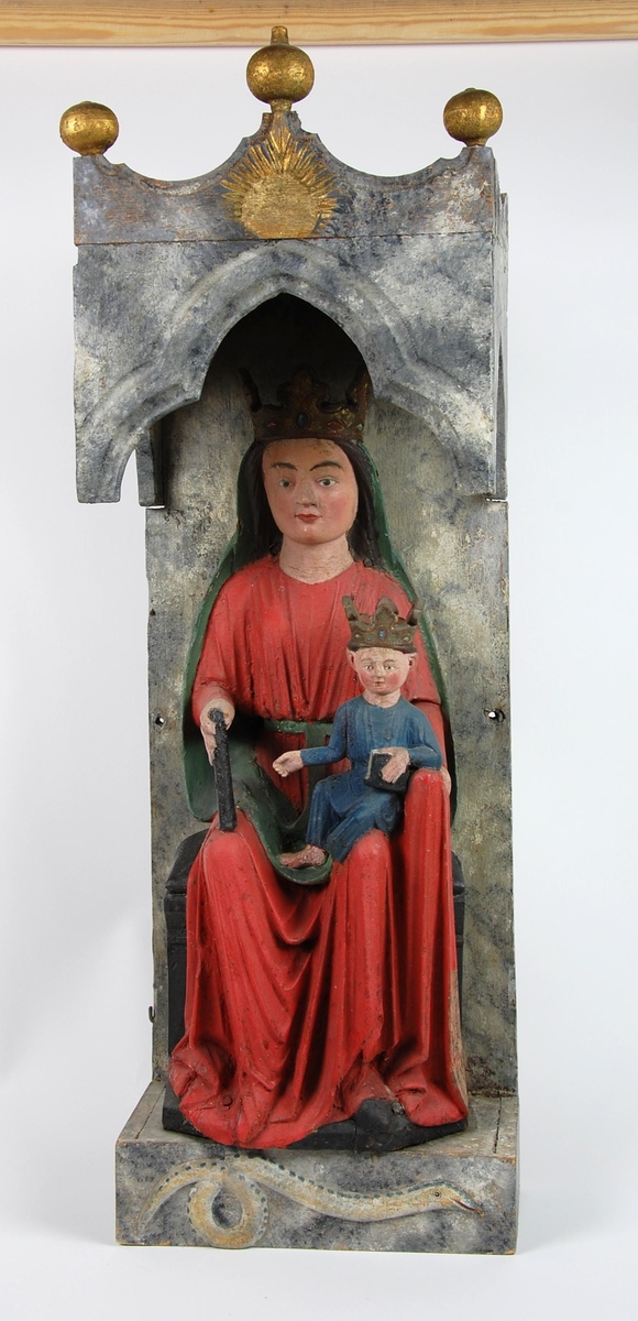 Madonna med barnet sittende på en trone under en baldakin. På toppen av baldakinen er tre gullfargete knotter, og under Madonna er det en slange som kveiler halen. Skulpturen har senere maling. Maria har rød kjortel og grønn kappe, mens Jesusbarnet har blå kjortel.
