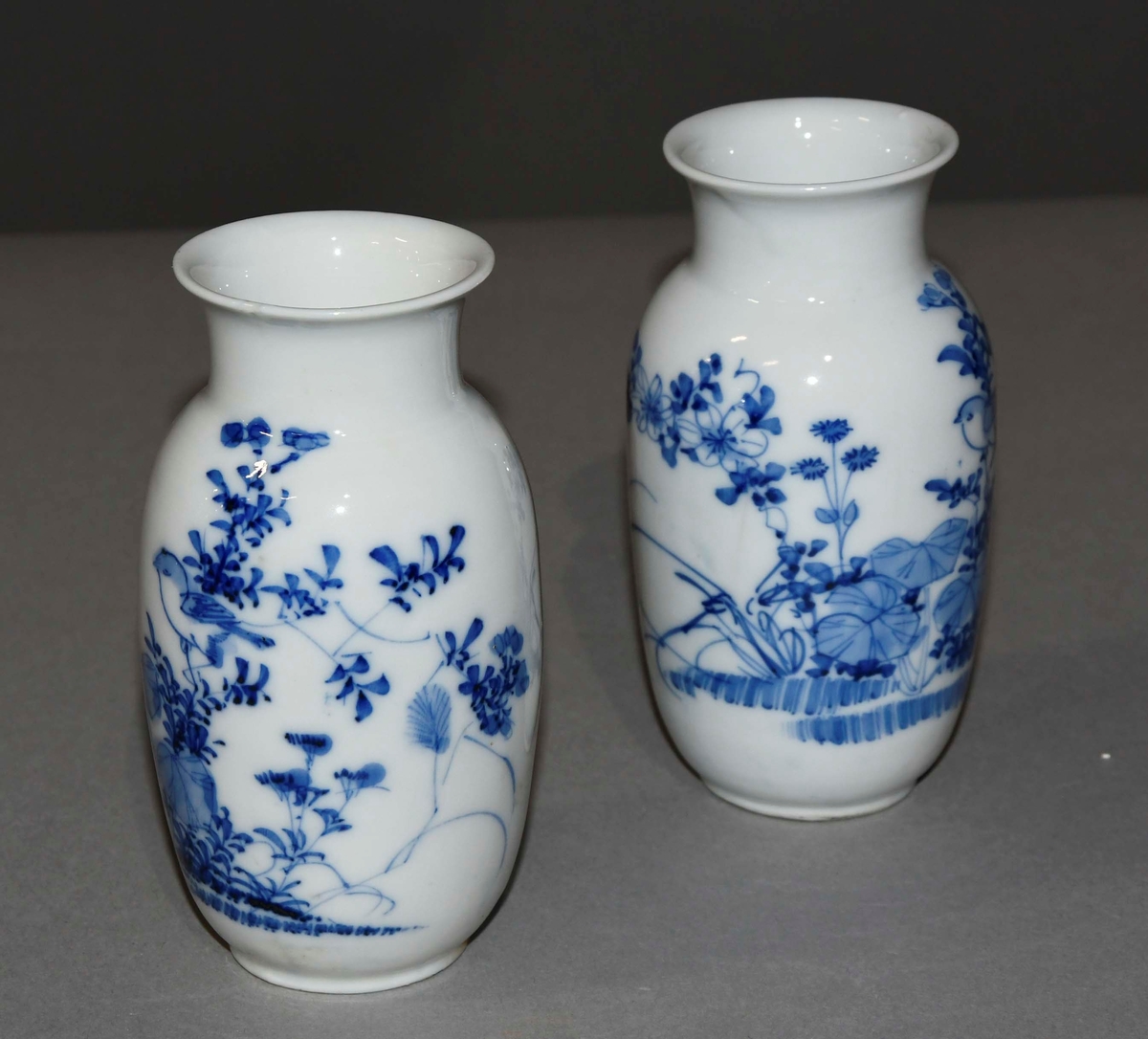 Vase av hvit porselen, med blå dekormaling av planter og fugler.