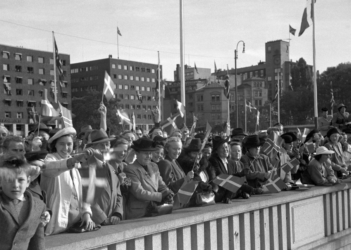 Kong Frederik og Dronning Ingrid på offisielt besøk i Norge.  Dansker som oppholdt seg i Oslo, fikk tildelt en spesiell plass på Rådhuskaia til å ønske det danske kongeparet velkommen. Her vifter de med det danske flagget.