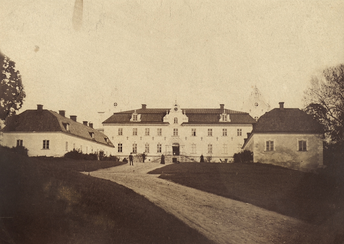 Tyresö slott, exteriören från framsidan. Framför entrén, på gårdsplanen står två män och två kvinnor. Tiden runt sekelskiftet 1900.