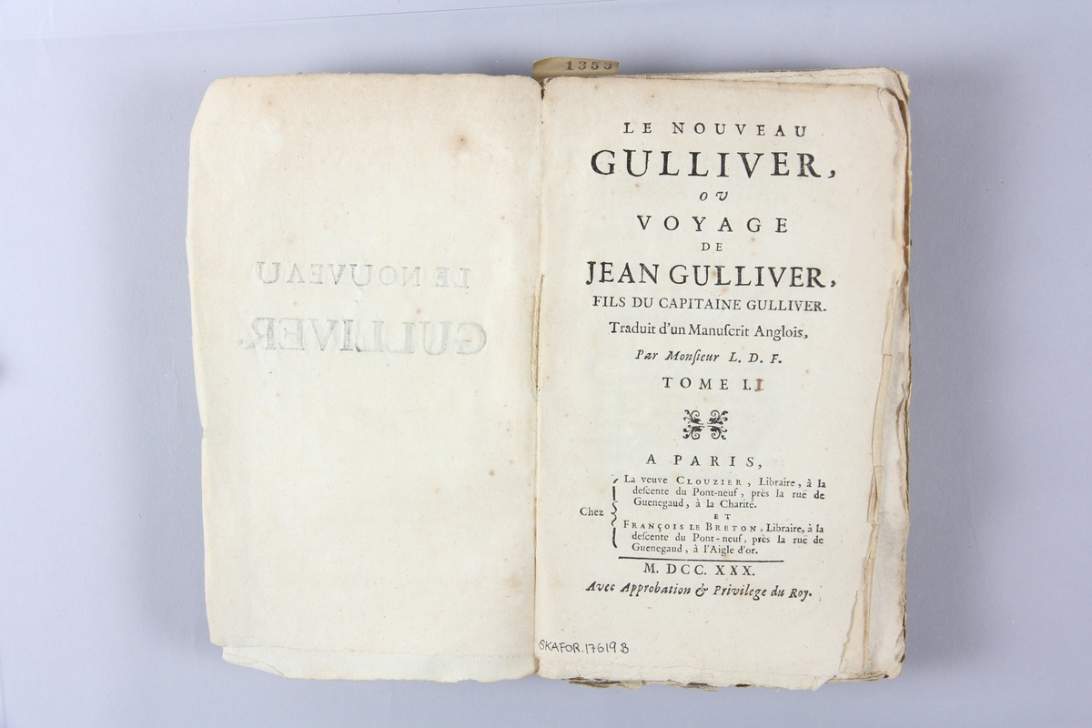 Bok, häftad,"Le Nouveau Gulliver ou Voyage de Jean Gulliver", del 2, tryckt 1730 i Paris. Pärm av marmorerat papper, oskuret snitt. Blekt rygg med pappersetikett med volymens namn, svårläst,  och samlingsnummer.