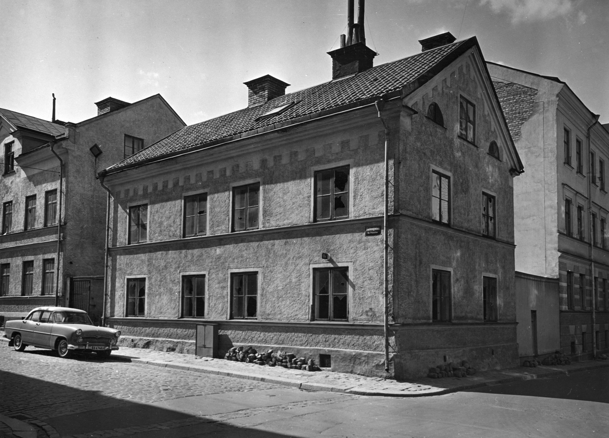 Denna byggnad som låg i korsningen av Vattengatan och Luntgatan i kvarteret Pokalen var ett emirehus i två våningar från 1800-talets mitt.  Fotografiet är taget i samband med rivningsansökan 1958. Vy mot nordväst.