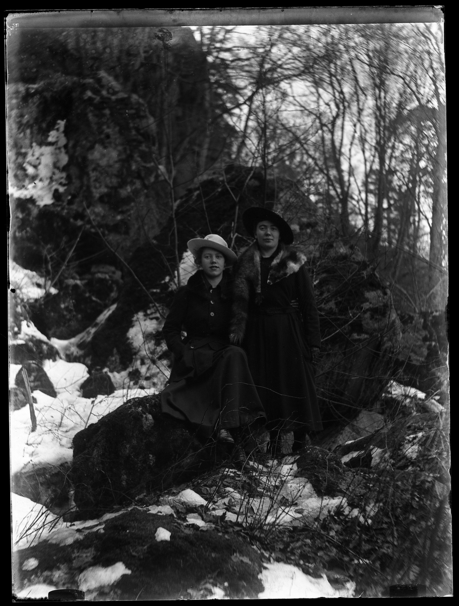Signe och Eva fotograferade i skogen. Lite snö ligger på marken.