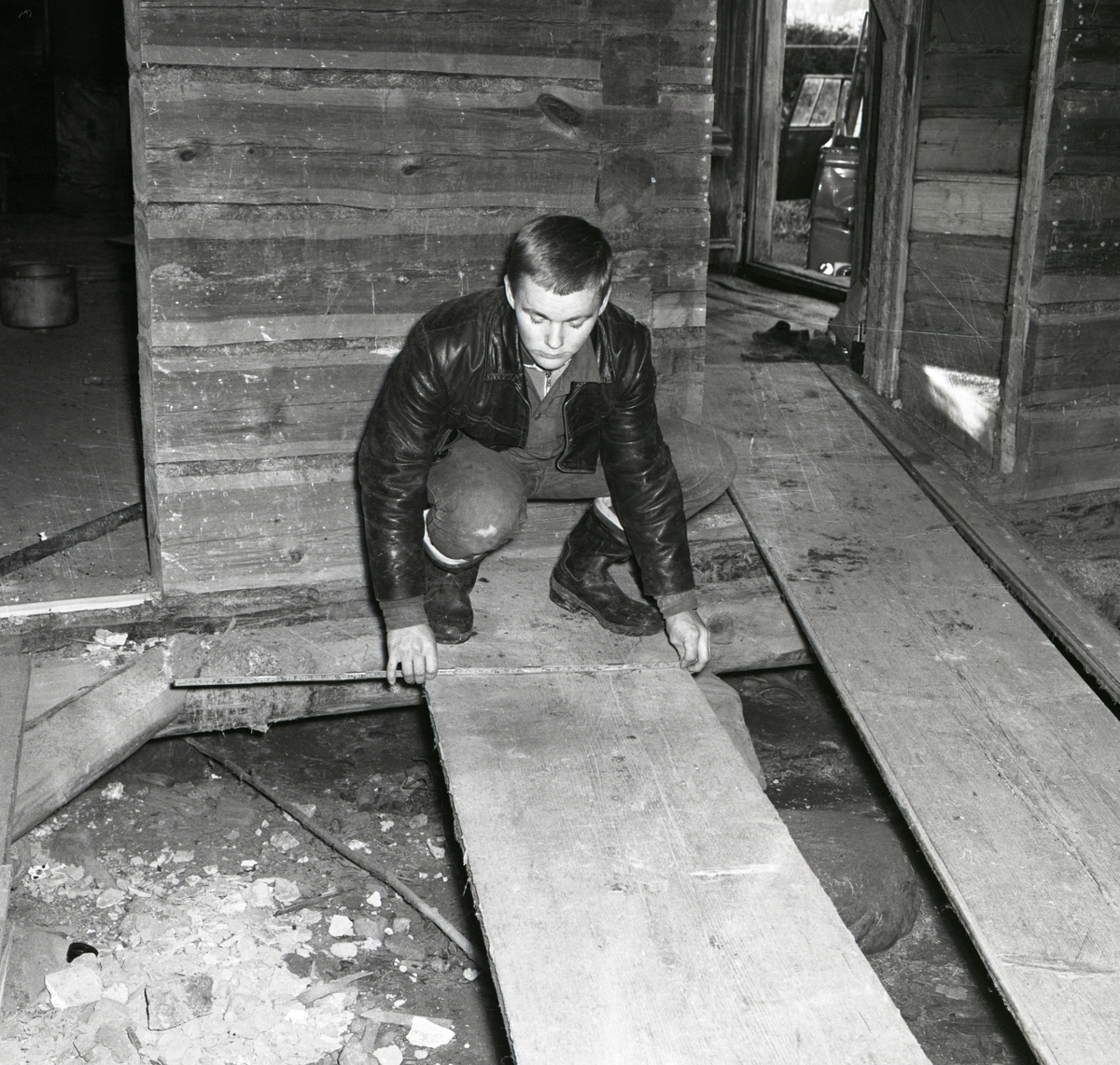 En man mäter en golvplanka, 1967.