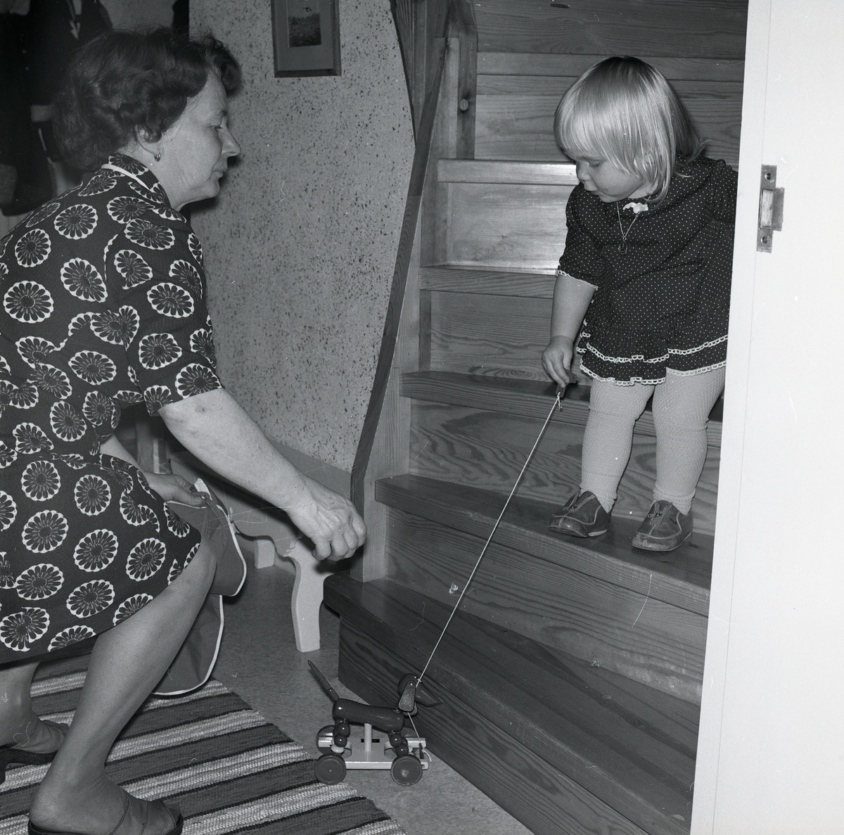 Adéle Mickelsson hjälper sitt barnbarn med en leksakshund, julafton 1974.