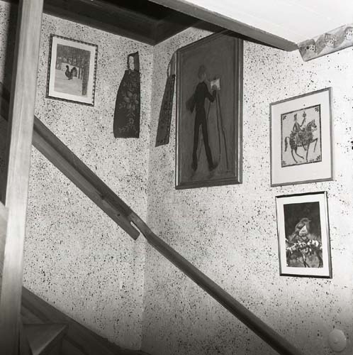 En interiörbild med stänkmåleri och tavlor samt ledstång till trappan vid gården Sunnanåker, 1984.