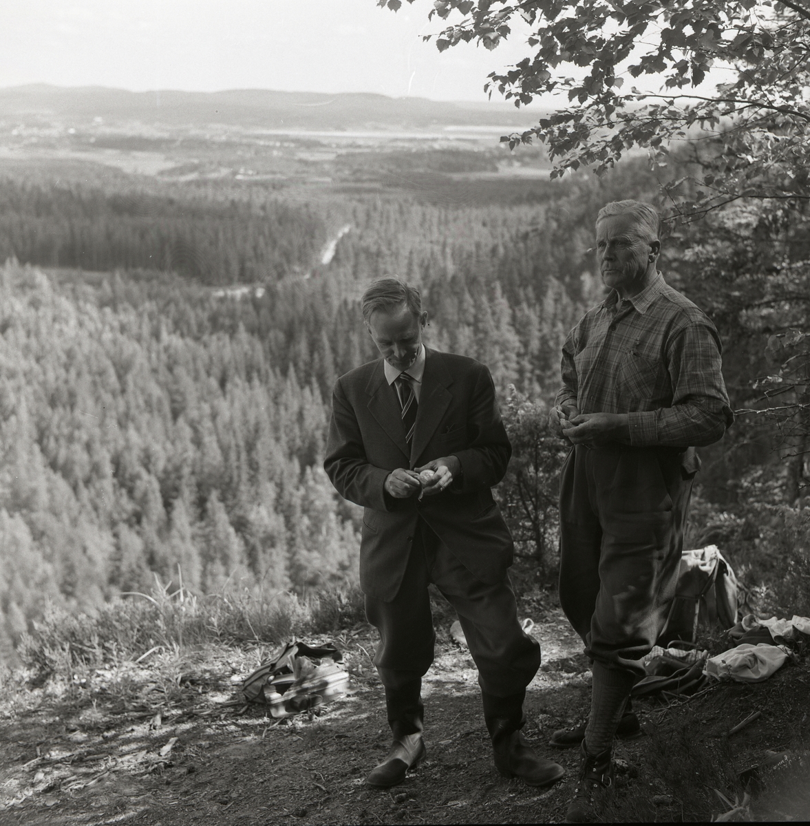 Två män står på Bolleberget i Bollnäs och bakom dem syns en utsikt över en dalgång med skog, 6 juli 1957.
