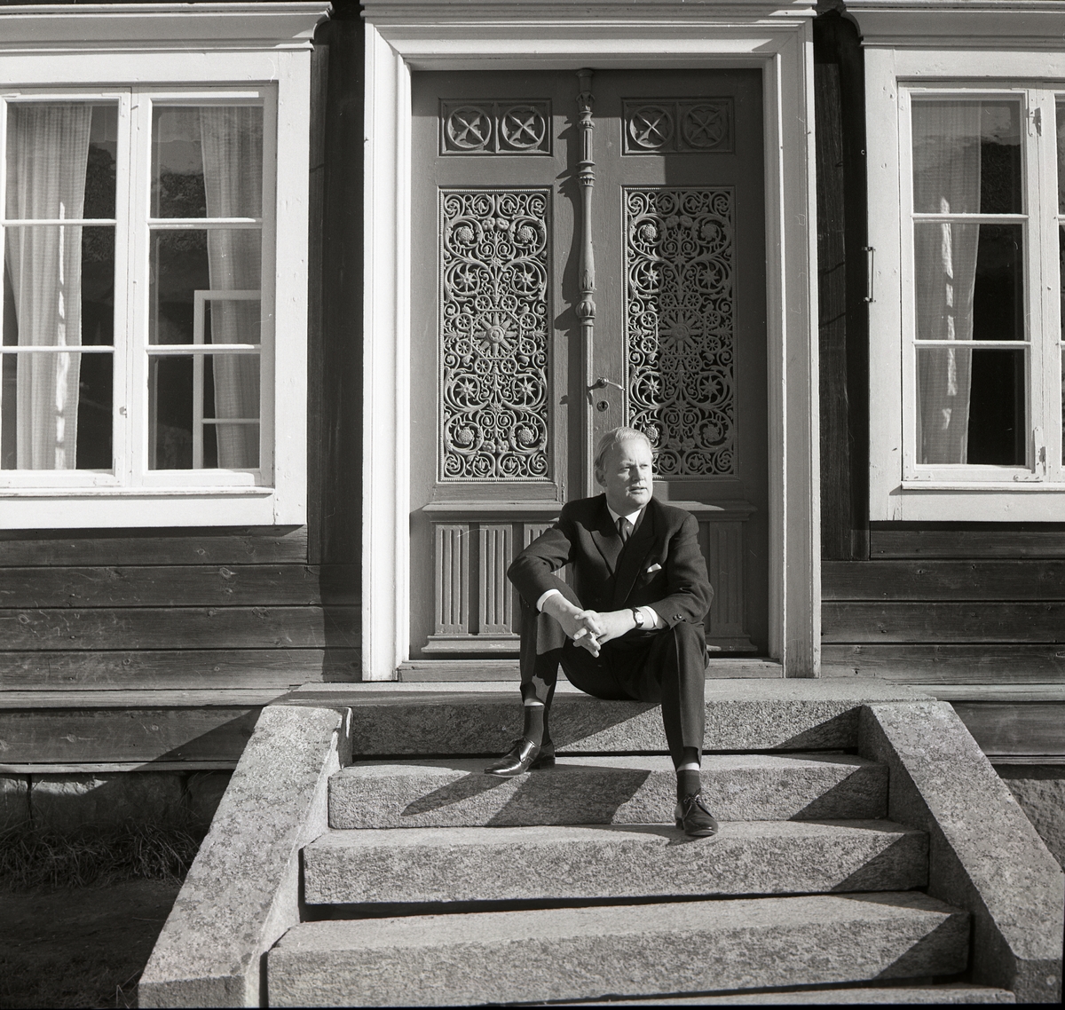 Bo Setterlind, författare, poet och psalmdiktare sitter på en trappa framför en utsirad dubbeldörr, 26 september 1968.