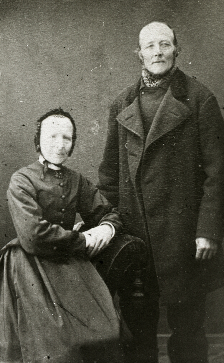 En man står bredvid en sittande kvinna.
