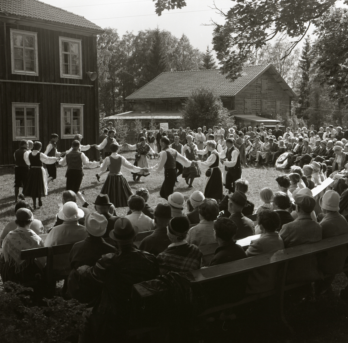 En grupp uppträder med ringdans inför publiken vid hembygdsgården i Rengsjö, 1973.