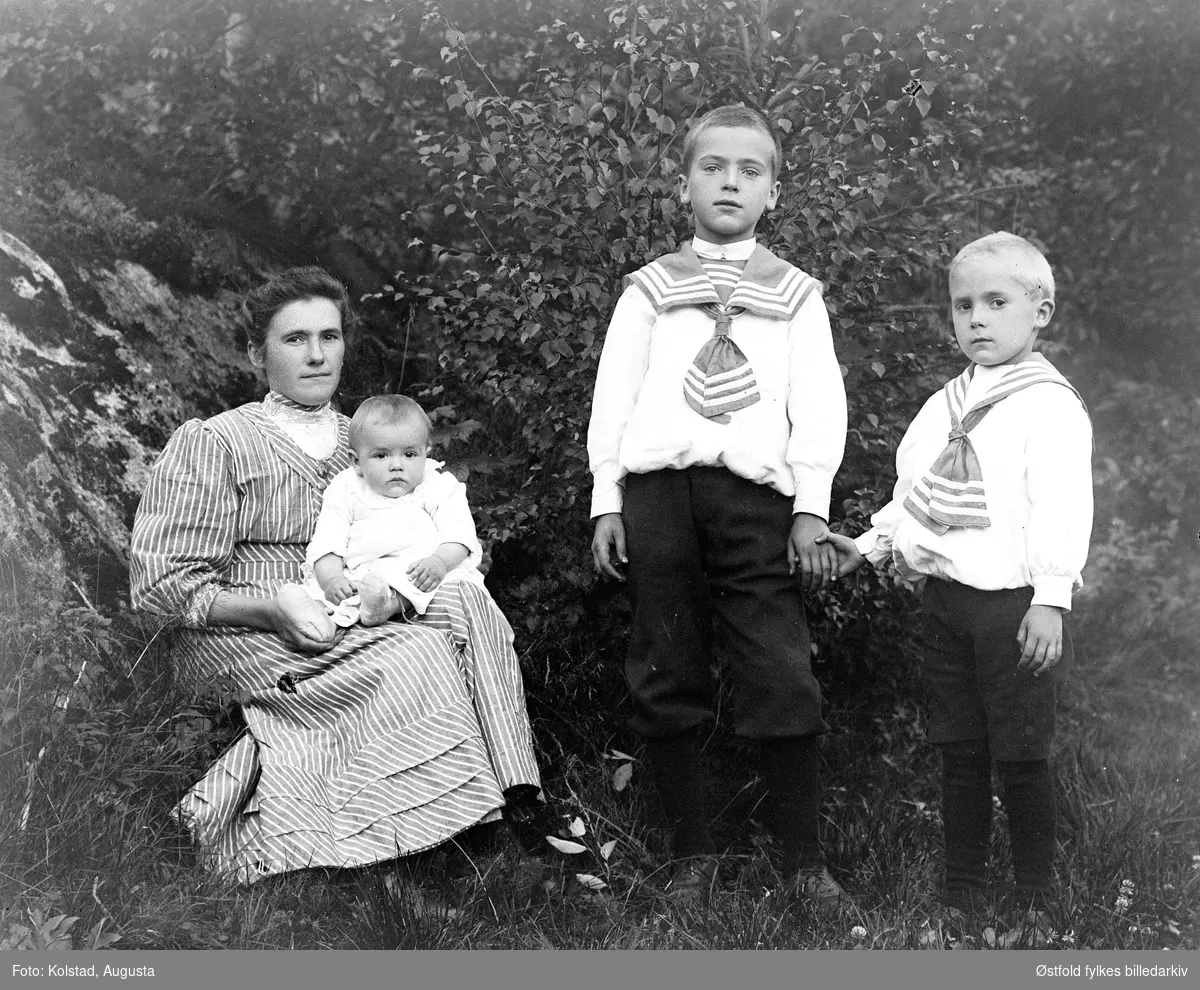 Gruppeportrett av mor med tre barn. Ukjente.
