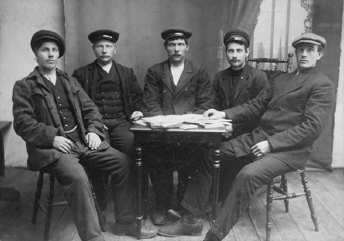 Leirfjord, Simsø. De tre persone i midten er fra venstre brødrene Konrad Larsen (f. 1885) og Petter Larsen (f. 1879) fra Simsø og deres søskenbarn Petter Olsen (f. 1886), også fra Simsø. De to som sitter ytterst er ukjent.