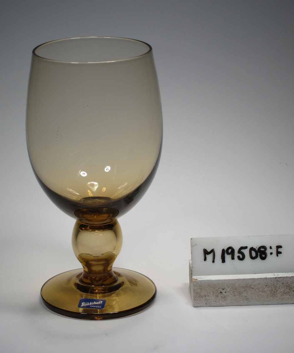 Ölglas tillhörande servis "Desirée".
Äggformad kupa, ben med kula, skivfot.
Rökgulbrunt klarglas.
Ovan angivna mått avser maxdiameter.
Inskrivet i huvudkatalogen 1968.
Funktion: Ölglas