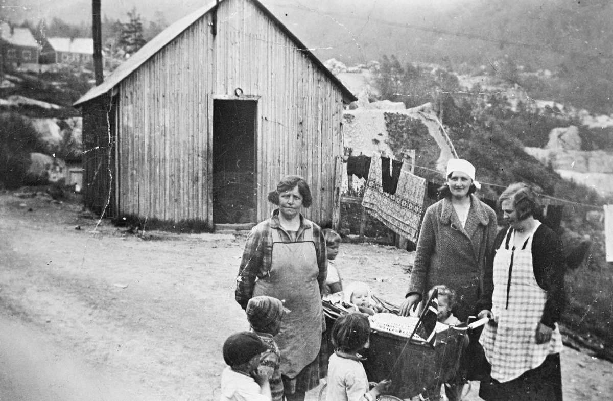 Kvinner og barn framfor vaskehuset i Brakkebyen i Tyssedal