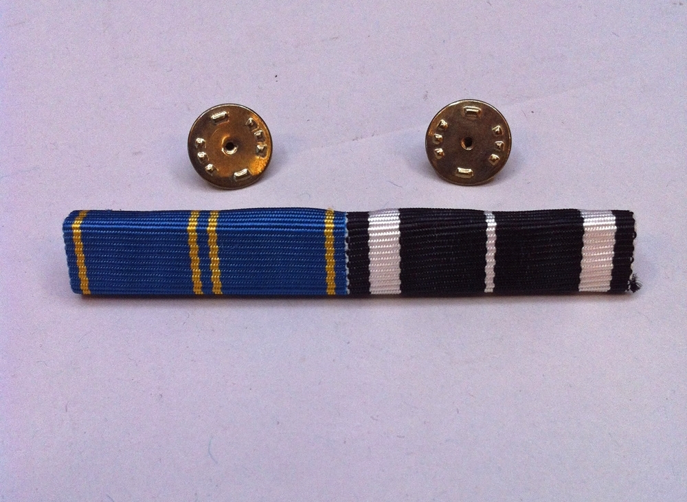 Släpspänne bestående av två ihopmonterade släpspännen - ett blågult samt ett svartvitt medaljband, med två fästen baktill. Släpspännena bars till uniform till vardags eller när full medalj ansågs olämplig, och placerades på kavaj- eller jackbröstet över ett eventuellt ficklock. Det blå medaljbandet tillhör Hemvärnets silvermedalj och det svarta tillhör Järnvägarnas Driftvärns förtjänstmedalj i silver.