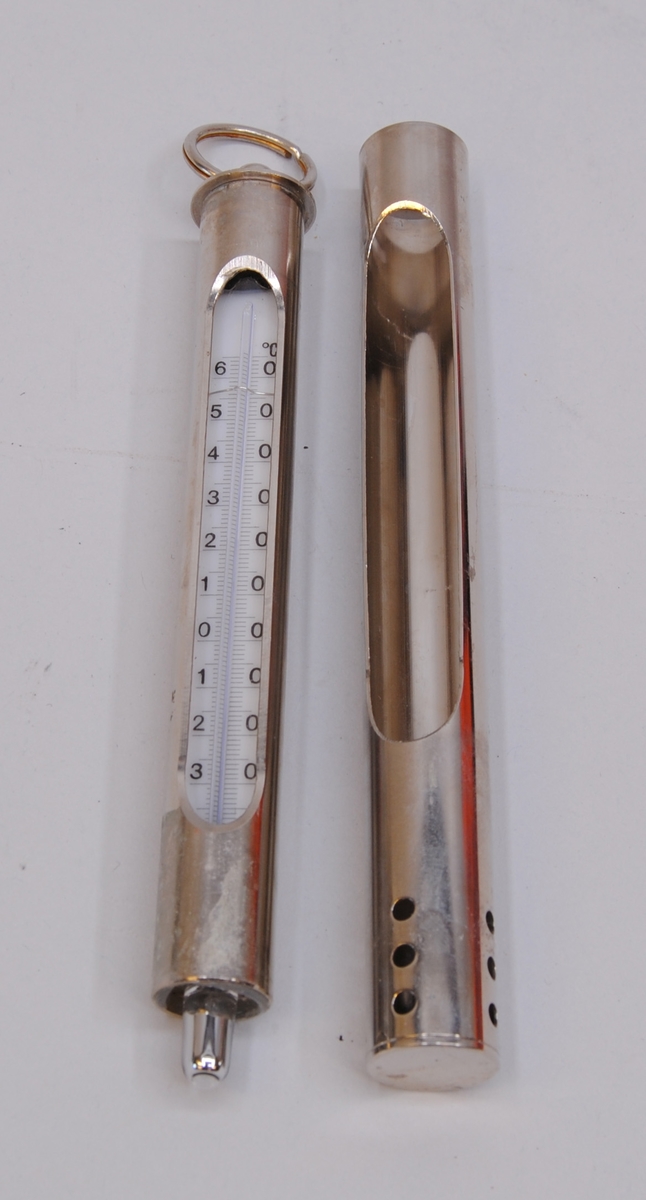 Termometer (A) med etui (B). Termometern innehåller kvicksilver. I toppen av termometern sitter en nyckelring.
Termometern har en placering i ett fack inuti fodralet (Jvm23131-2) bredvid en höjdmätare (Jvm23131-5-6).