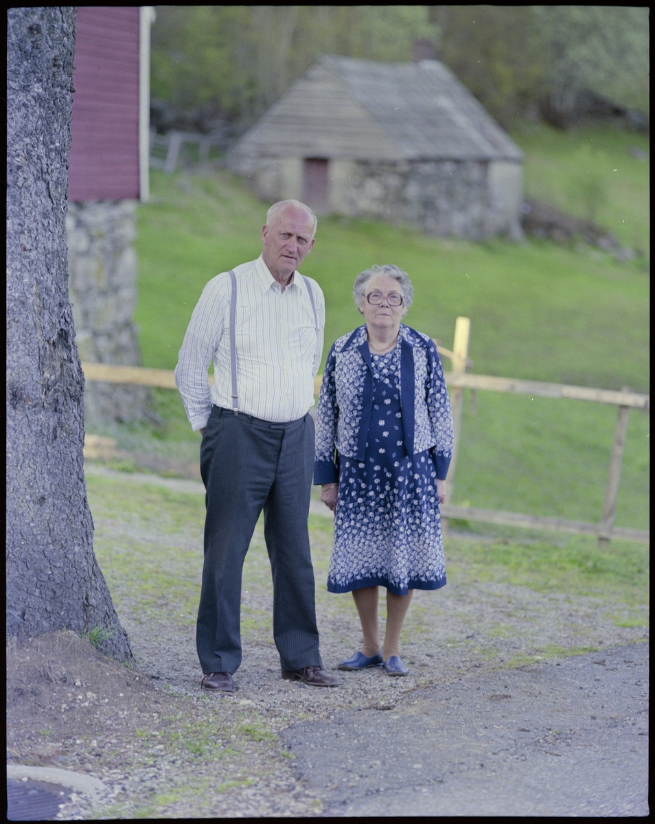 Hans og Helene Røkenes smiler til fotografen på et gårdsbruk.