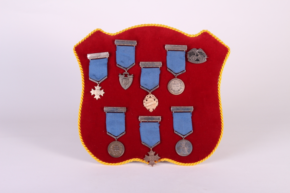 Åtte medaljer montert på fløyelskledd merkeskjold. Medaljesamling etter Lars Øglænd.