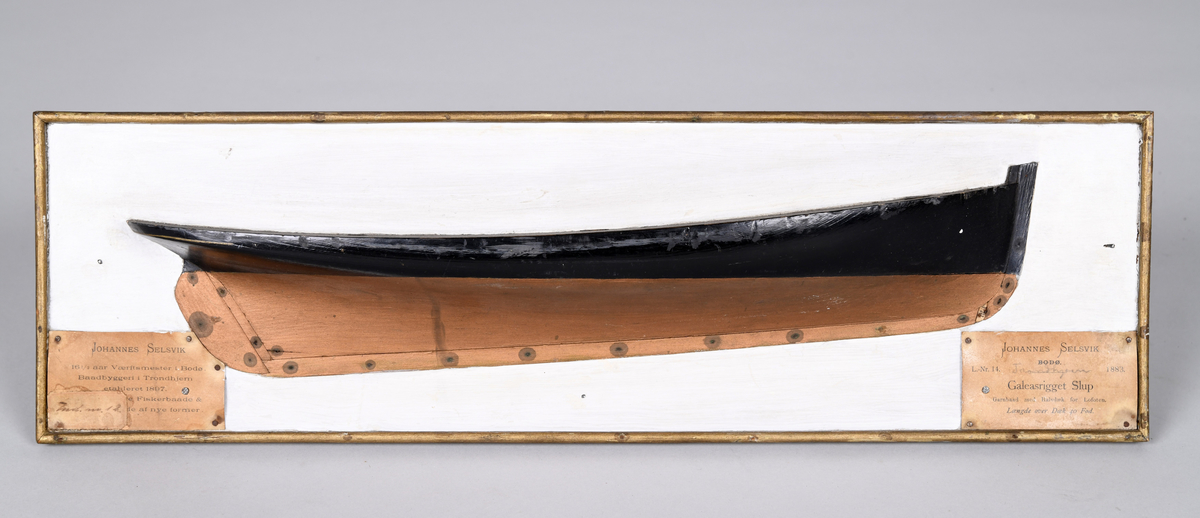 Halvmodell av en galeasrigget slupp, festet på en plate av treverk med ramme. L.-Nr. 14. Trondhjem (håndskrevet) 1883. Galeasrigget Slup. Johannes Selsvik, Bodø
