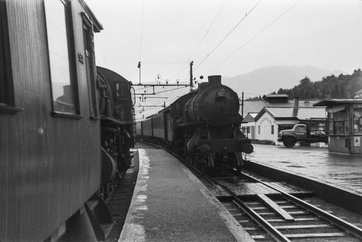 Kryssing på Minde stasjon. Begge togene trekkes av damplokomotiv type 31a.