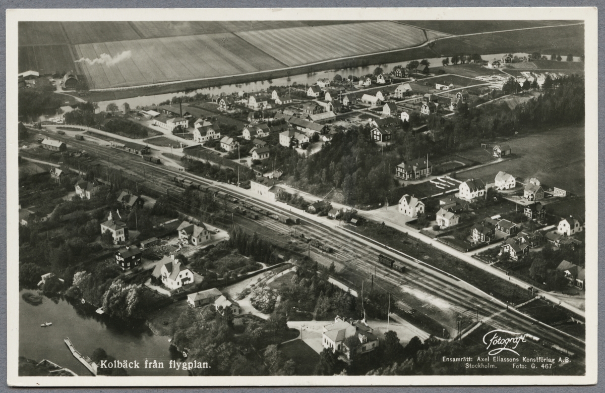 Flygfoto över Kolbäck med station, samhälle och Freden sjön i bild.