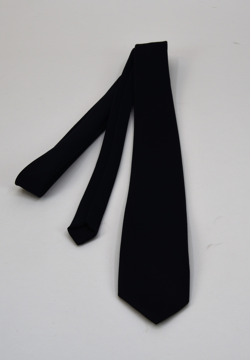 En mörkblå slips med märkning fastsytt på baksidan.