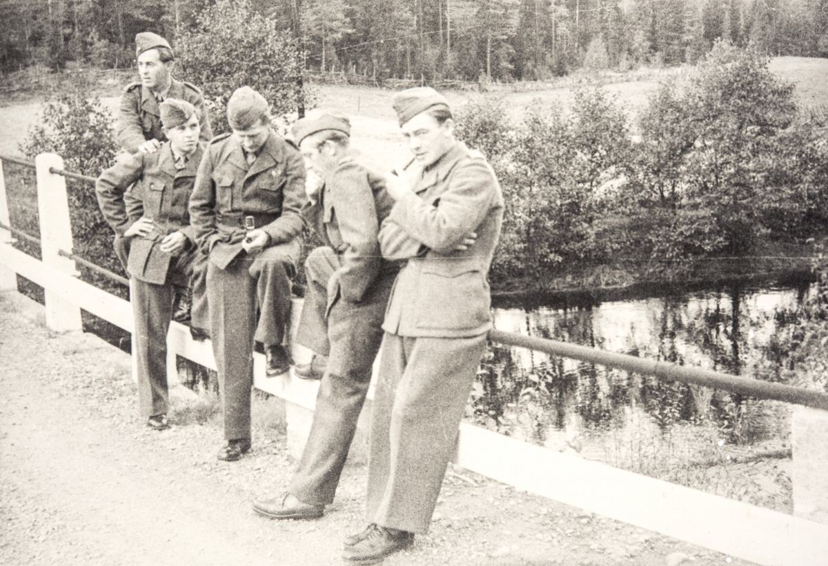 Norske polititropper står på en bro ved et vann eller elv i Sverige under 2. verdenskrig.