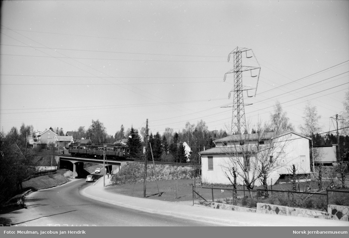 Motorvogntog på Røabanen passerer viadukten over Sørkedalsveien ved Huseby skole.