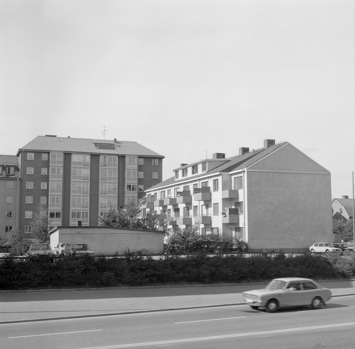 Kvarteret Dalkullans norra del som det tog sig ut 1973. Det höga bostadshuset har då som nu adressen Snickaregatan 27. Fastigheten till höger bar tills den revs adresserna Drottninggatan 10-12. Vy över Hamngatan mot väster.