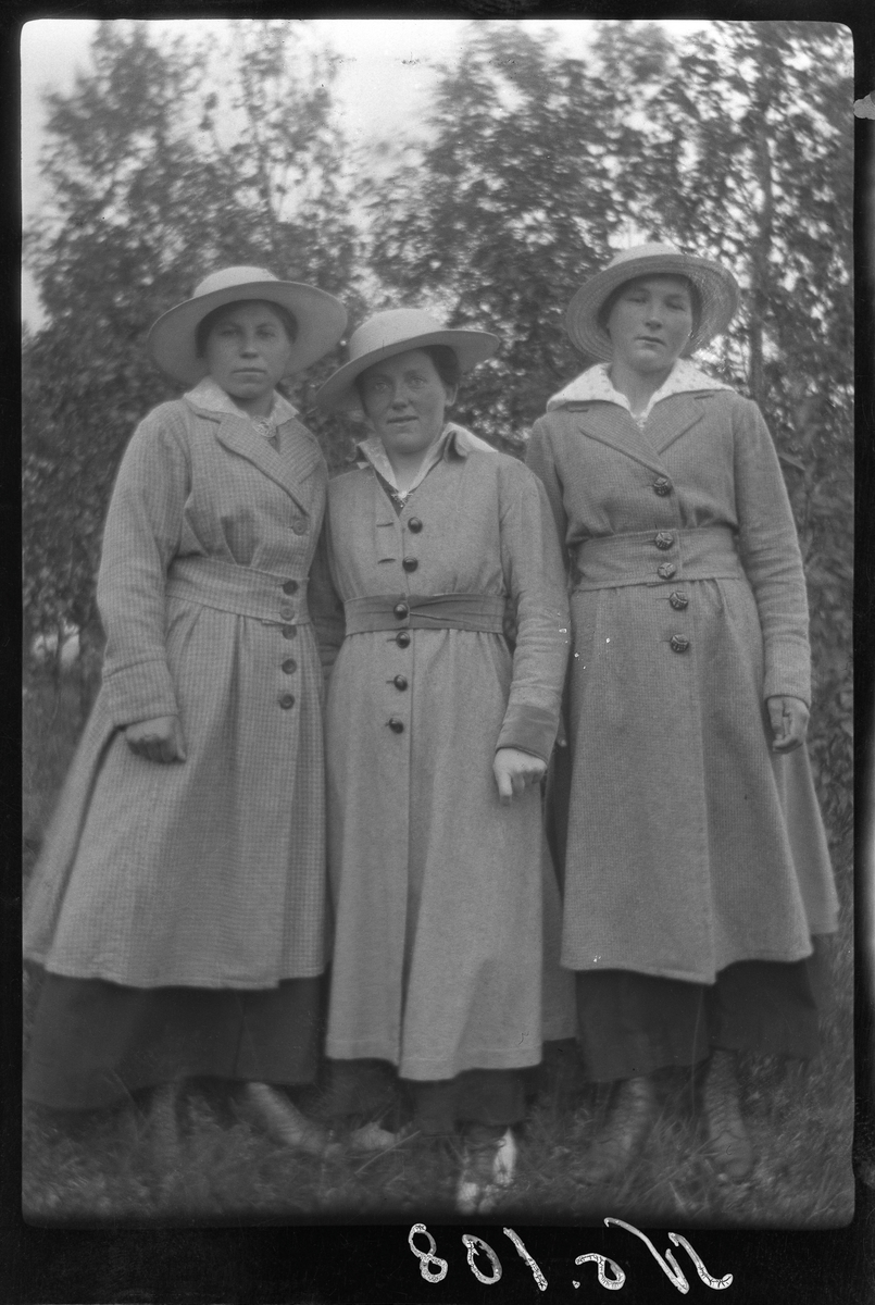 Portrett av tre kvinner stående utendørs.