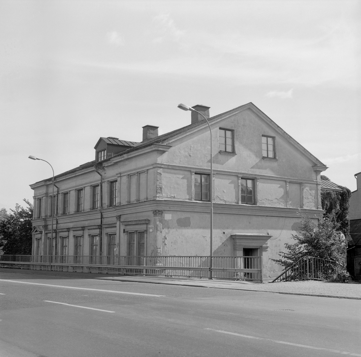 Drottninggatan 2 är ett representativt exempel på de putsade hus i nystilar som uppfördes längs gatan när den anlades under det sena 1800-talet. Bryggare Jacob Wilhelm Svensson lät uppföra huset omkring 1875. Efter att Drottningbron anlagts i slutet av 1940-talet fick byggnadskroppen som synes ett inklämt läge. Här dokumenterad av Östergötlands museum inför rivning. Vy mot sydost.