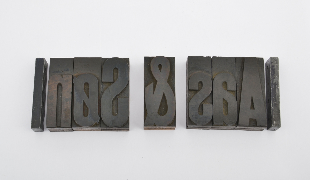 Syv tretyper i plakatskrift og to vinkelhaker i bly: Aas & Søn. Oppsettet er antagelig bruk i utstilling i Håndverkerens hus (Normannsgate 3).