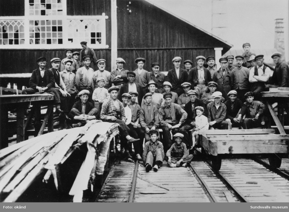 Eriksdals sågverk med arbetarstyrka. Bilden är tagen sommaren 1928. Sågen hade legat nere några år, men 1928 återupptogs verksamheten igen då som lejdsågning för Skönvik. Längst fram sitter ströpojkarna Torolf Mejdelf ca 1911 och Arne Sundström, som då var 12 år. Ströpojkarnas och särarens uppgift var att lägga planken till rätta när plankbäraren la av sin börda, som kunde innehålla 30-40 bräder. Förtjänsten per timma var för en ströpojke var 25 öre. Lön för 14 dagar brukade bli 25 kr och 20 öre.