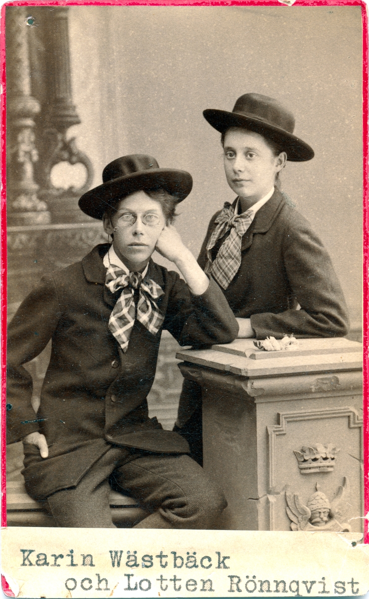 Karin Wästberg och Lotten Rönquist i en ateljé, båda har manskläder.