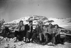 Fem voksne og en jente på skitur i fjellet