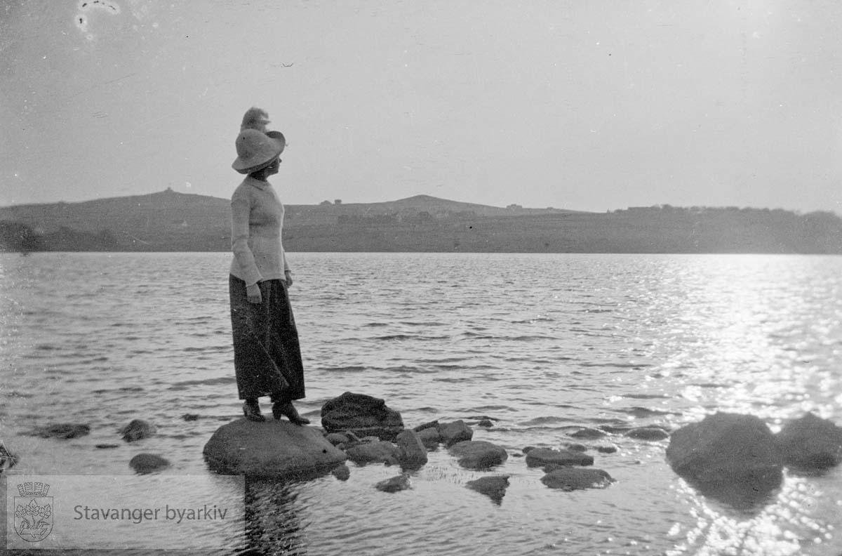 Kvinne med hatt i vannkanten