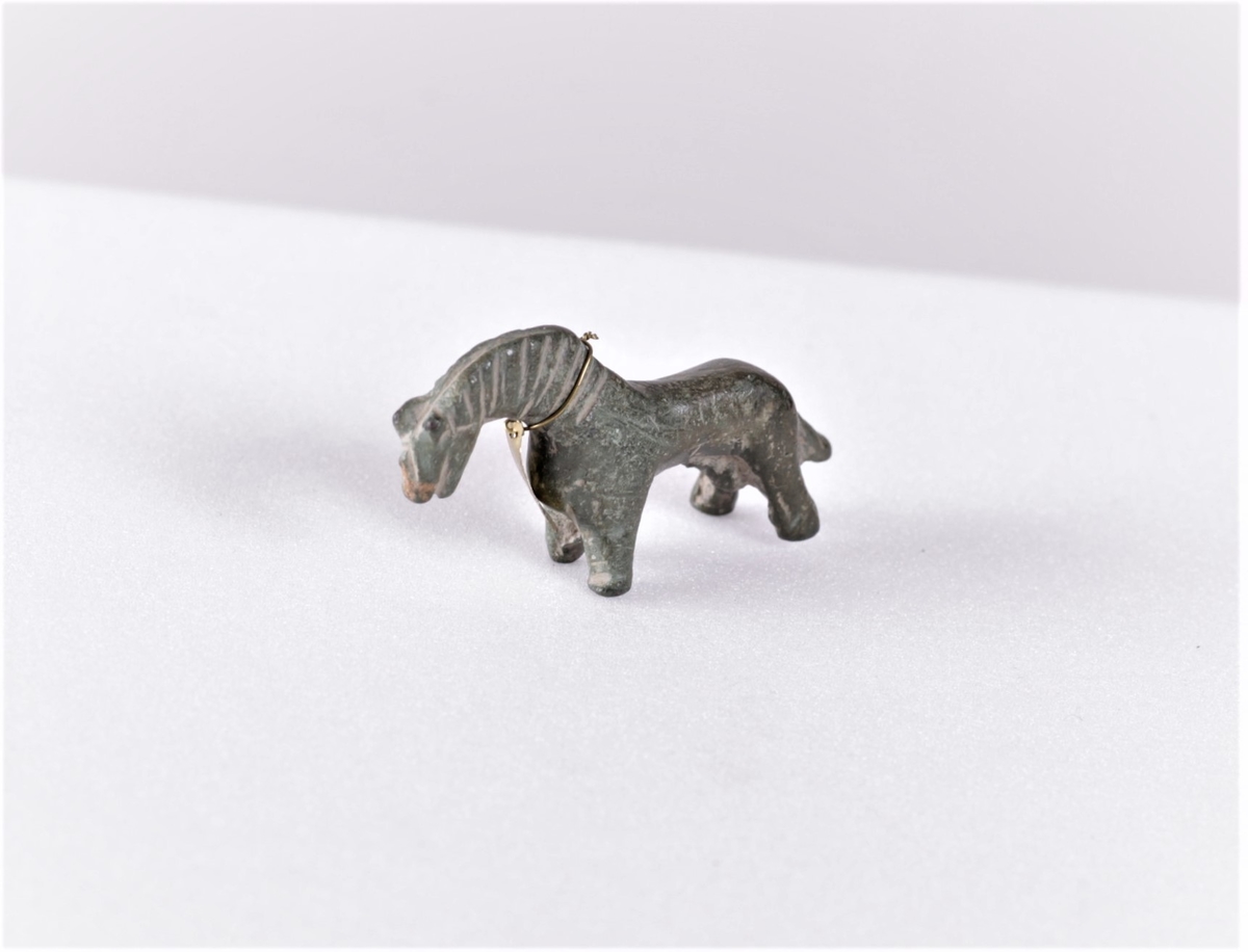 Vektlodd i bronse med form som en liten hest, veier 1/2 mark. Funnet på gården Nettum, Balke og er fra middelalderen.