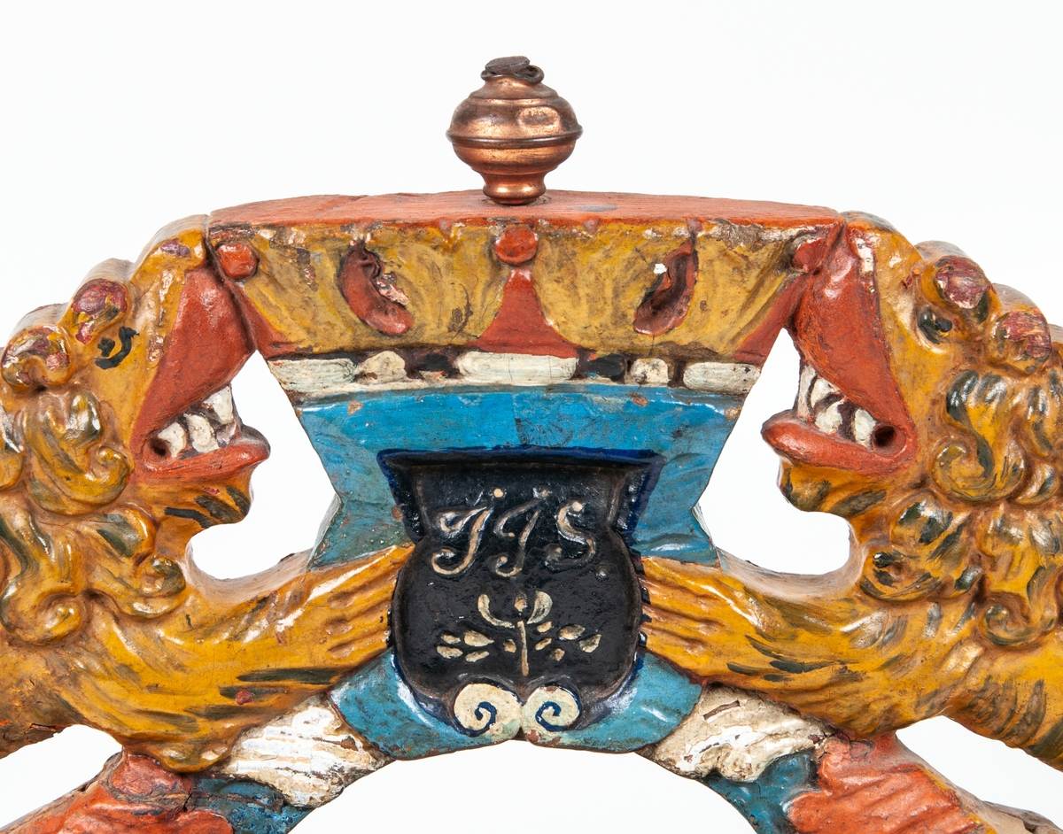 Selbåge i trä, föreställande två lejon och kunglig krona.
Daterad enligt påskrivt "Anno 1704".