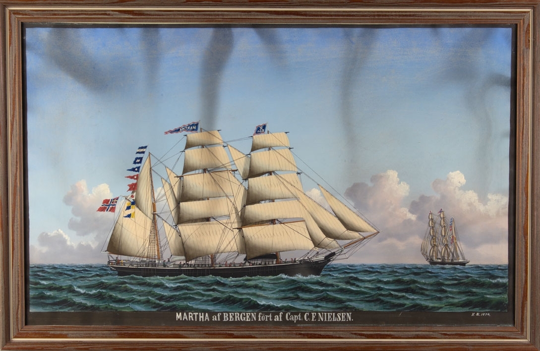 Skipsportrett av bark MARTHA med full seilføring samt signalflagg på åpen sjø. Fører flagg med sildesalat i akter. Til høyre i motiv sees skipet fra akter.