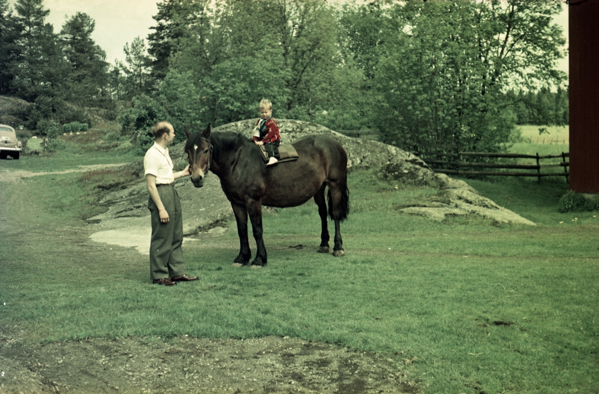 Geir Huset på hesterygg mens far Arnulf passer på. Stedet er gården Huset i Askim juni 1957.